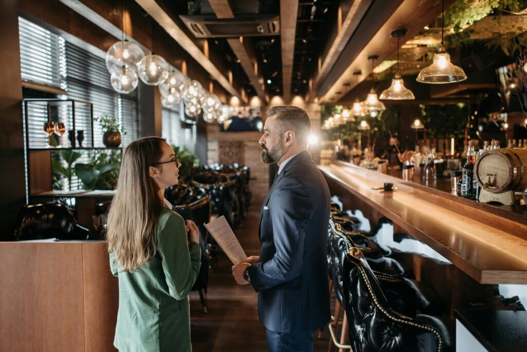 Two professionals discussing in a sophisticated bar setting with contemporary design.